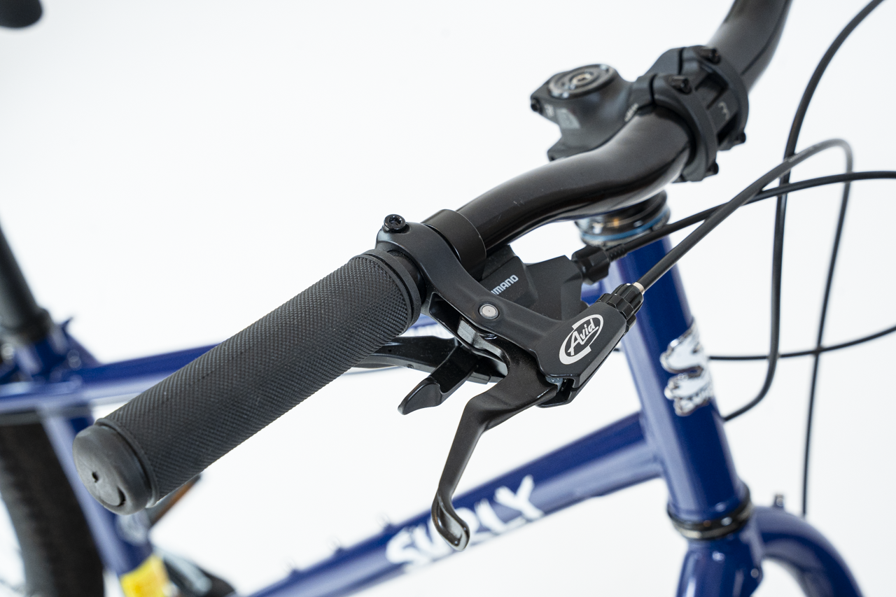 Close-up of a bicycle handlebar with brake lever on a white background