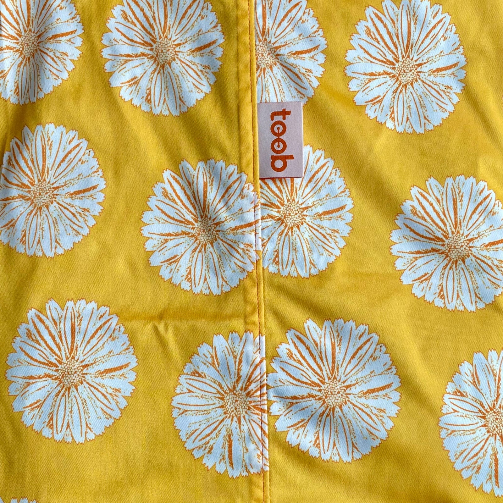 Floral patterned fabric with a 'toob' brand tag on a yellow background