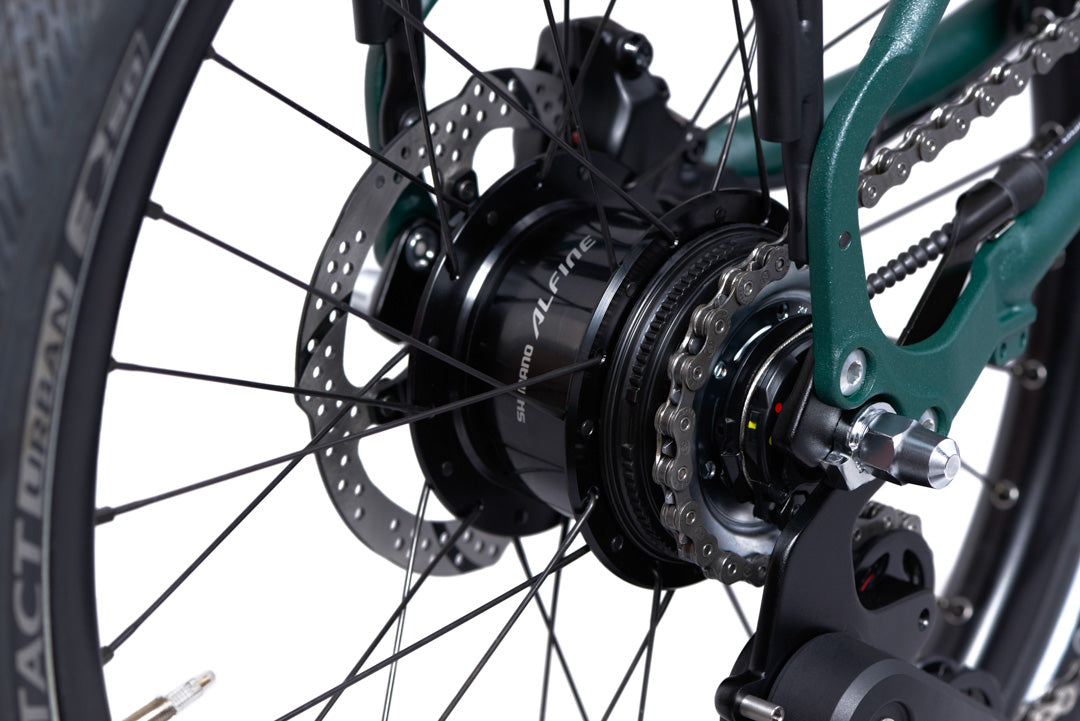 Brompton G Line Close-up of a bicycle wheel with gear and chain mechanism on a white background