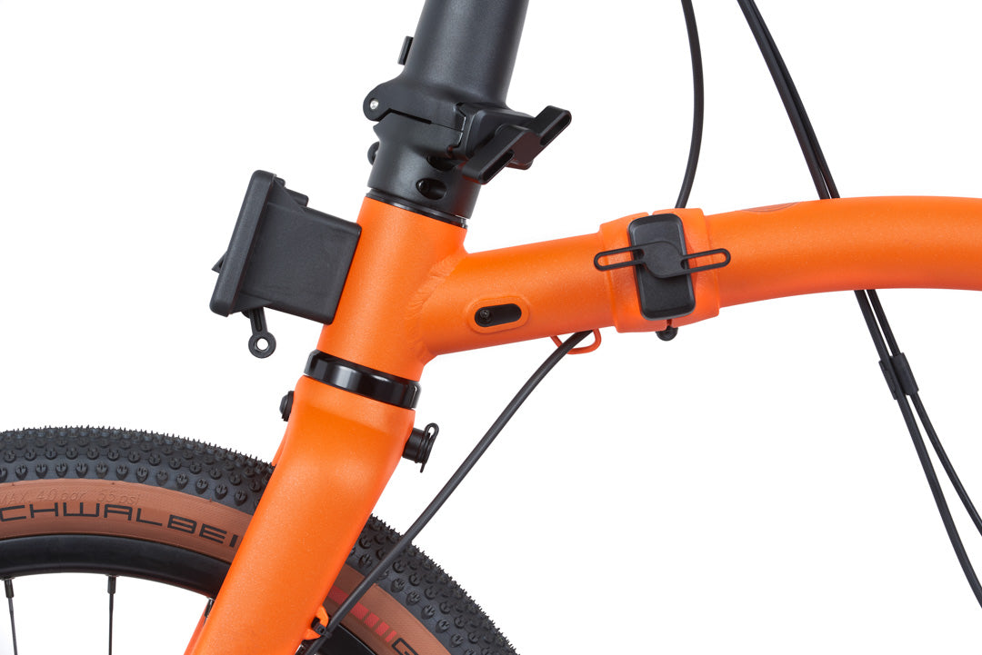 Brompton G Line Close-up of an orange bicycle frame with black components on a white background