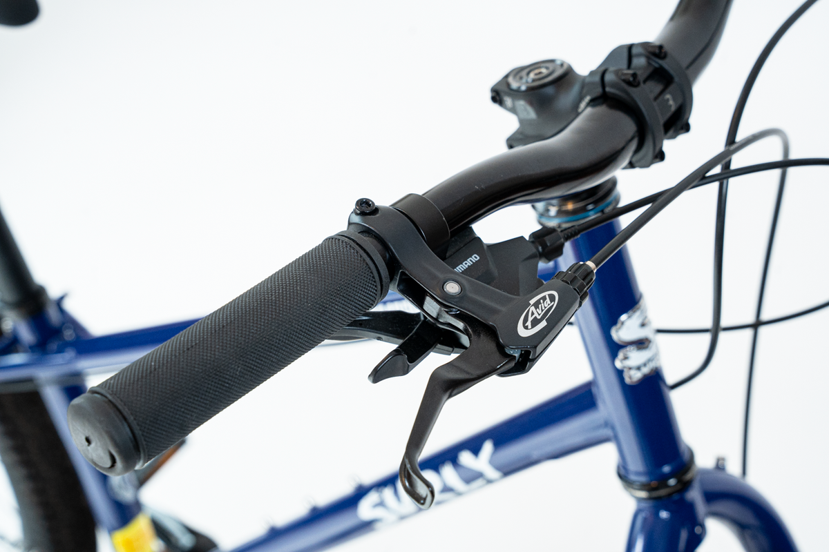 Close-up of a bicycle handlebar with brake lever on a white background